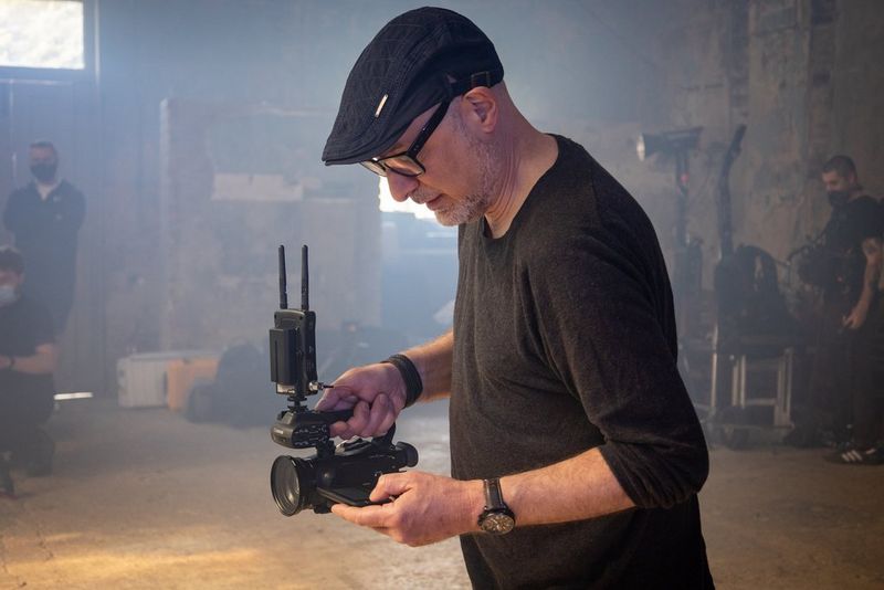 A man films in a low-lit room with a Canon XA45 professional camcorder.