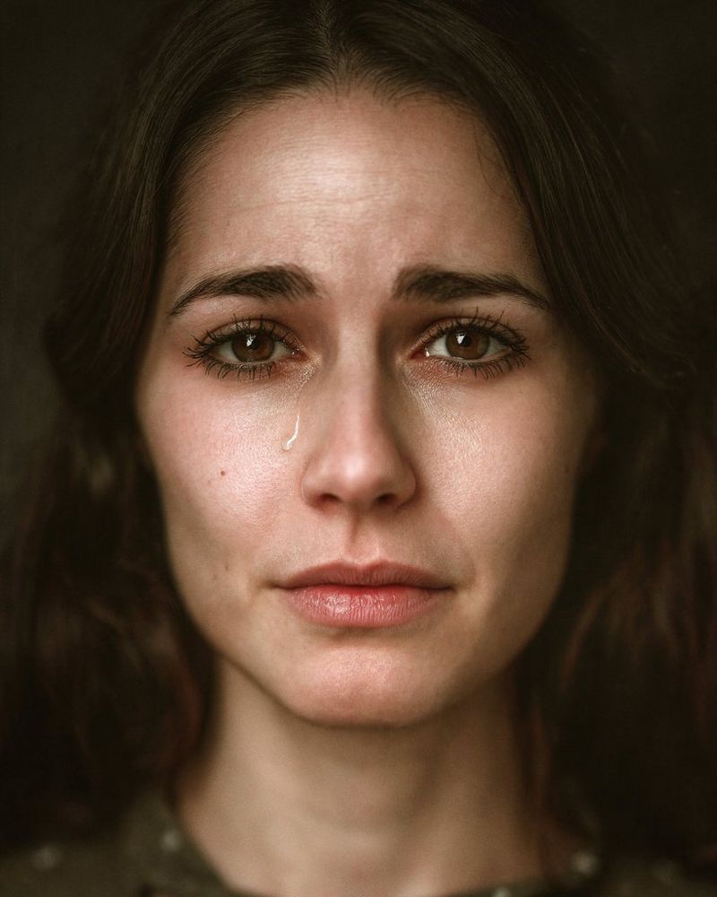 Il primo piano del viso di una donna, con una lacrima che le scende sulla guancia.