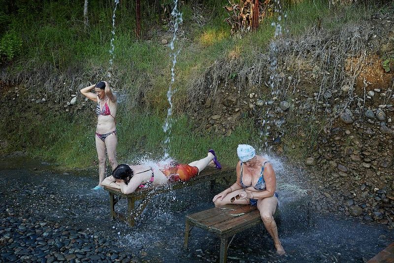 Three women in bikinis enjoy the natural hot springs in Kyndyg, Abkhazia.