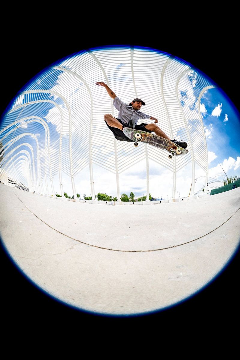 A circular fisheye photo of a skateboarder pulling a trick in the air, taken using a Canon RF 7-14mm F2.8-3.5L FISHEYE STM lens.