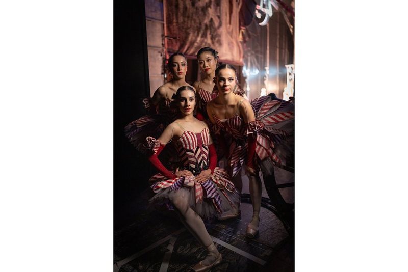 Four dancers from Birmingham Royal Ballet in costume pose for a group portrait at the side of a stage. Taken with a Canon RF 35mm F1.4L VCM lens.