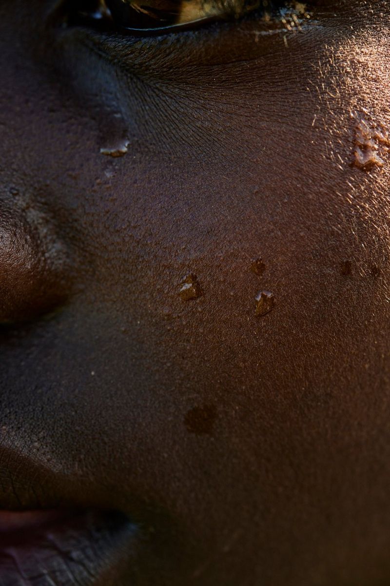 A close-up shot of droplets on a woman's face, taken on a Canon EOS R5 by Laura El-Tantawy for her series Carrying Life: Motherhood and Water in Malawi.