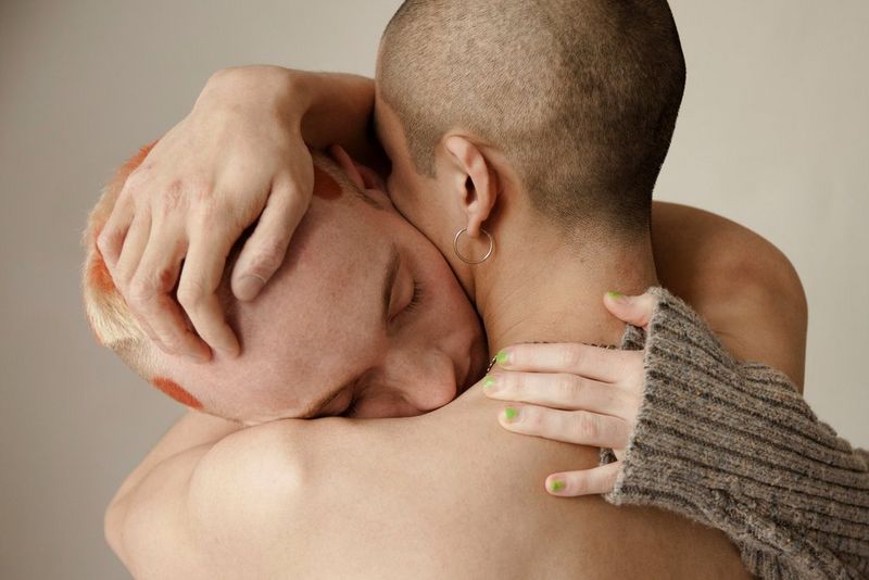 Twee figuren met geschoren haar - één met blote schouders naar de camera gedraaid - in een foto gemaakt op een Canon EOS 5D Mark II door Wanda Martin voor haar Lovers-serie.