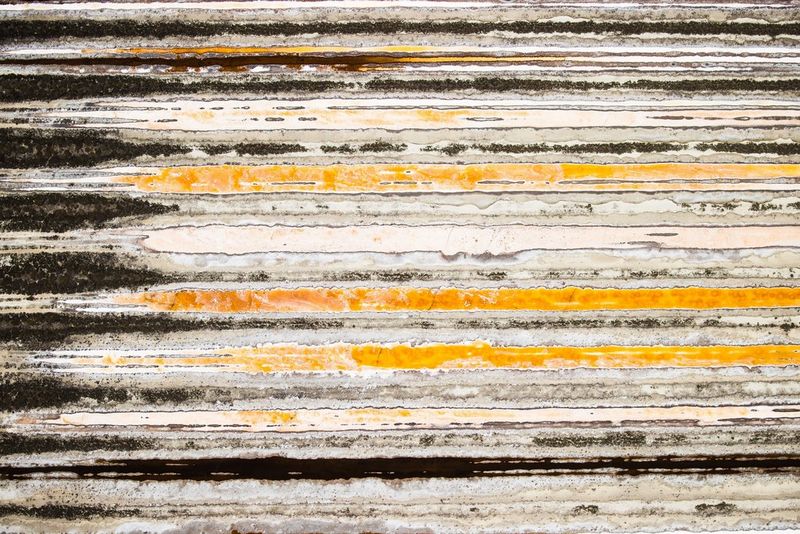 An aerial view of the Italian countryside depicting the landscape as a series of orange, black and grey stripes.