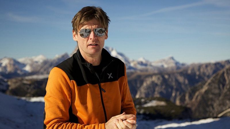 Landschapsfotograaf Mauro Tronto staat voor een bergketen met besneeuwde bergtoppen.