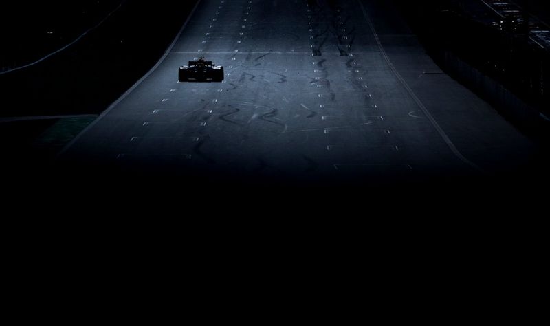 Een Formule 1-auto rijdt in de verte aan de linkerkant van een racecircuit, gefotografeerd met een Canon EOS-1D X Mark II door Vladimir Rys.