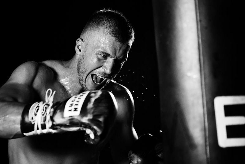 A black and white shot of a boxer throwing a punch.