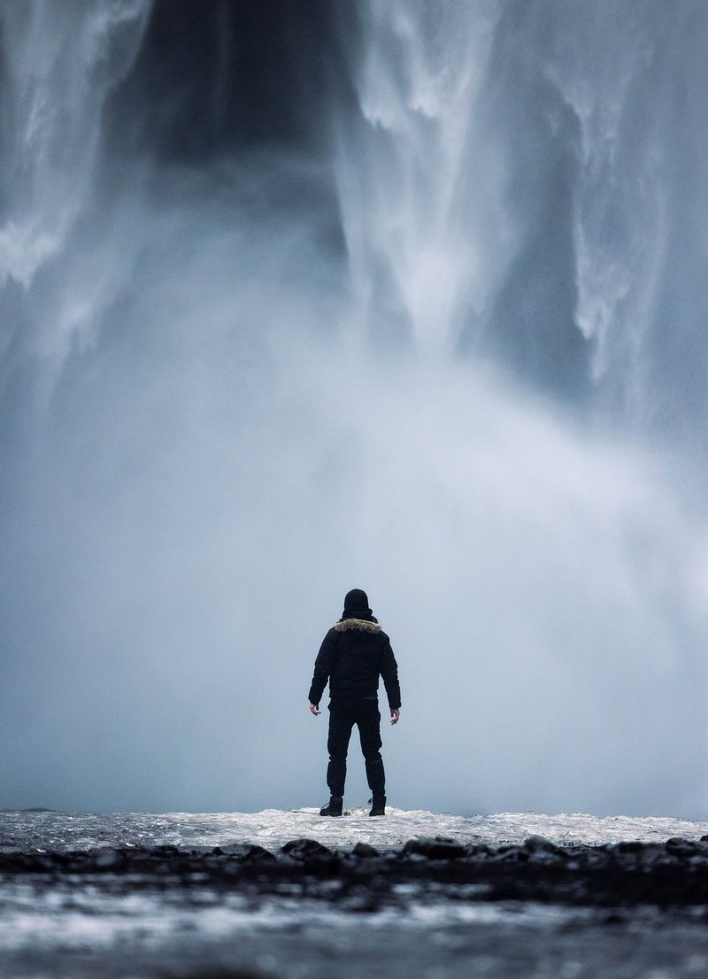 Foto di Harrison Brown di spalle di fronte a una cascata.