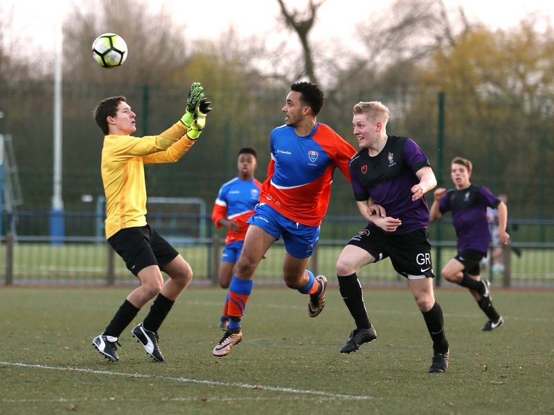 Young players battle for the ball during a match between England's Manchester Metropolitan University and the University of Manchester.