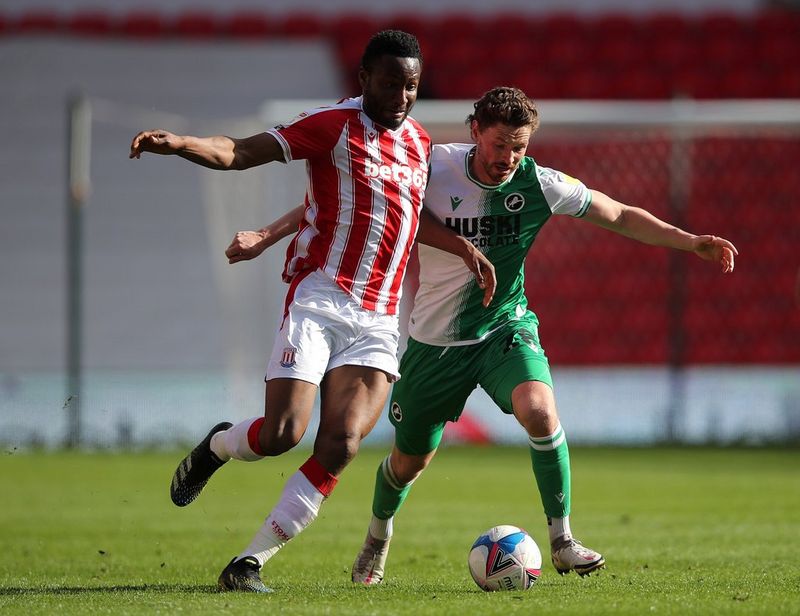 Stoke City's John Obi Mikel and Millwall's George Evans tussle for the ball in an empty stadium during the Covid-19 pandemic.