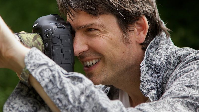 Фотограф Эндрю Фьюзек Питерс смотрит в видоискатель камеры Canon.