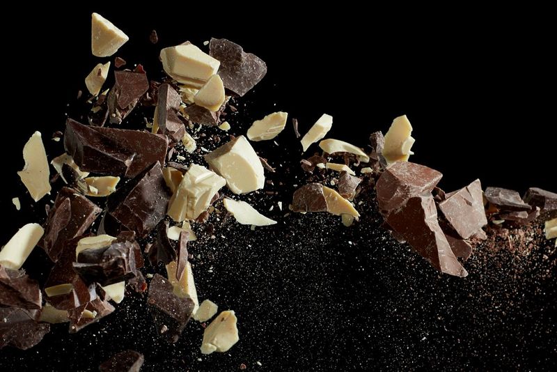 Chunks of dark, milk and white chocolate suspended in the air. 