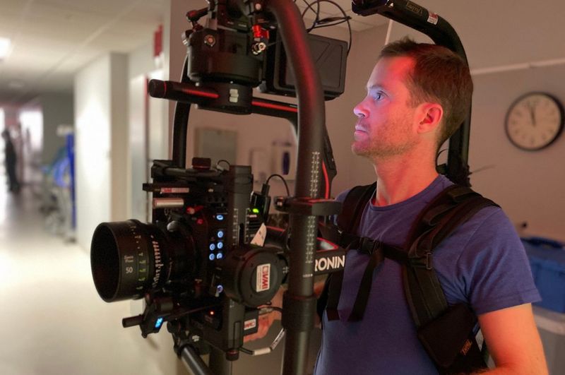DoP Patrick Smith with the Canon EOS C500 Mark II on a body-mounted rig in a hospital corridor.