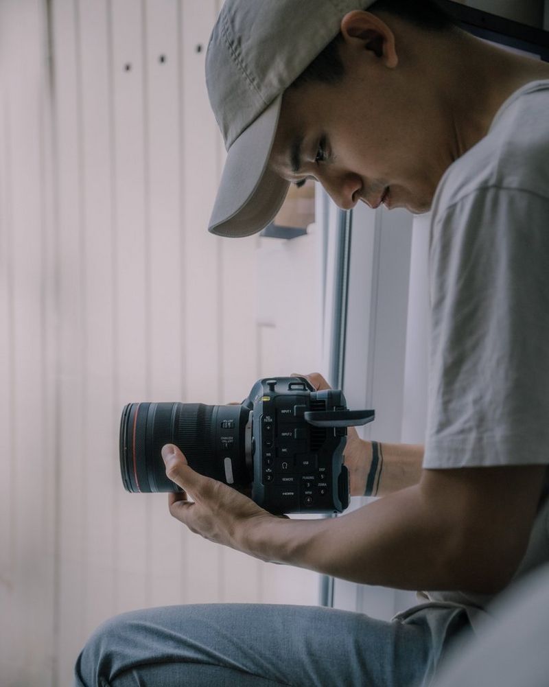 Режиссер Дэнни Фэн держит камеру Canon EOS C70 с объективом RF 24-70mm F2.8L IS USM и смотрит на дисплей с регулируемым углом наклона.