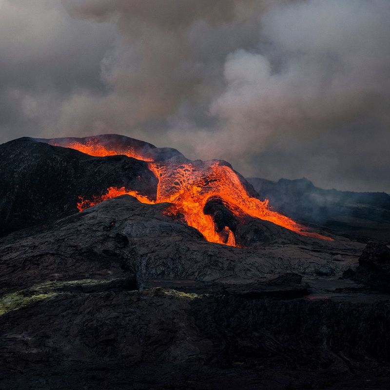 The Fagradalsfjall volcano in Iceland erupting with lava flowing out of it and smoke filling the sky. This image was captured by Paolo Pellegrin on a Canon EOS R5.