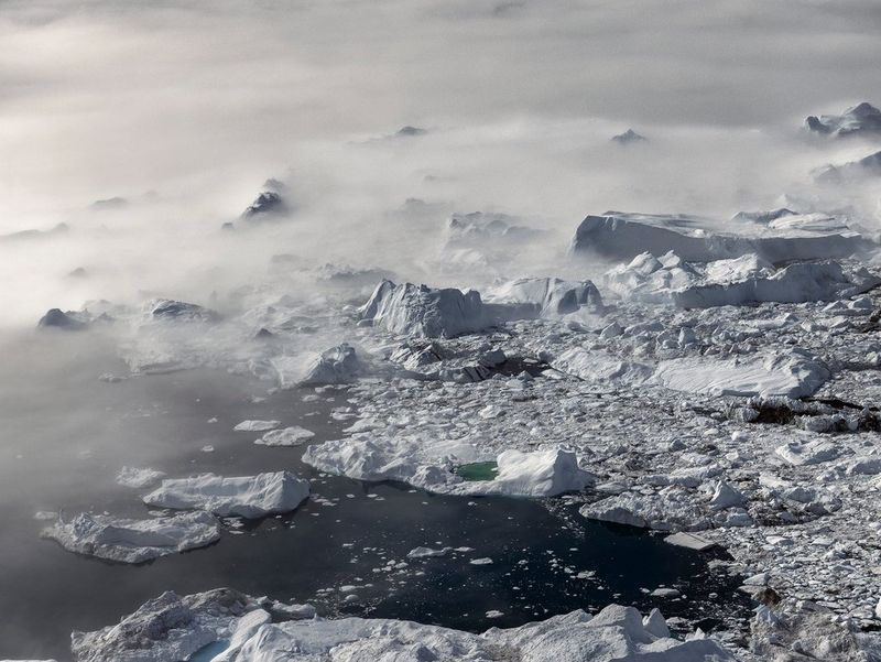 An iceberg in Disko Bay, Ilulissat, Greenland breaks into many pieces, showcasing the impact of mankind on the environment. This photograph was taken by Paolo Pellegrin on a Canon EOS R5.
