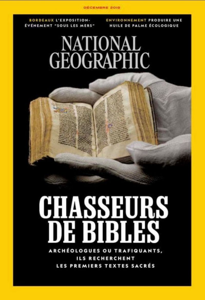 The cover of the French language edition of National Geographic Magazine features white-gloved hands holding an ancient bound Bible.