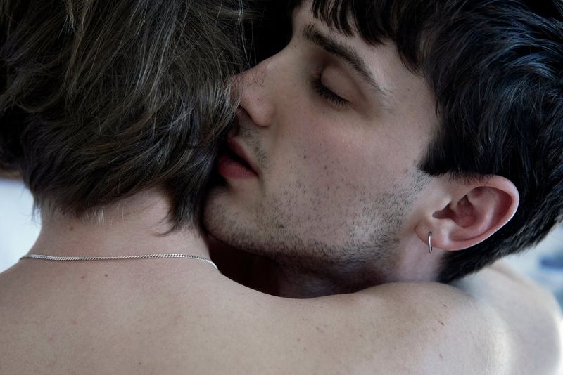 A close-up of a young couple embracing lovingly. 