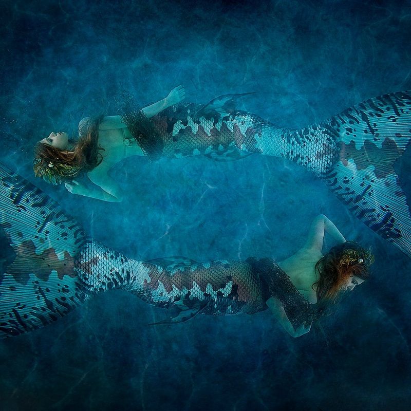 A mirrored image showing a model dressed as a mermaid underwater.