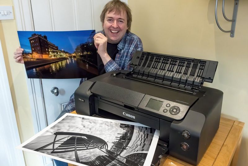 Keith Cooper holding a colour print beside a Canon imagePROGRAF PRO-300 printer.