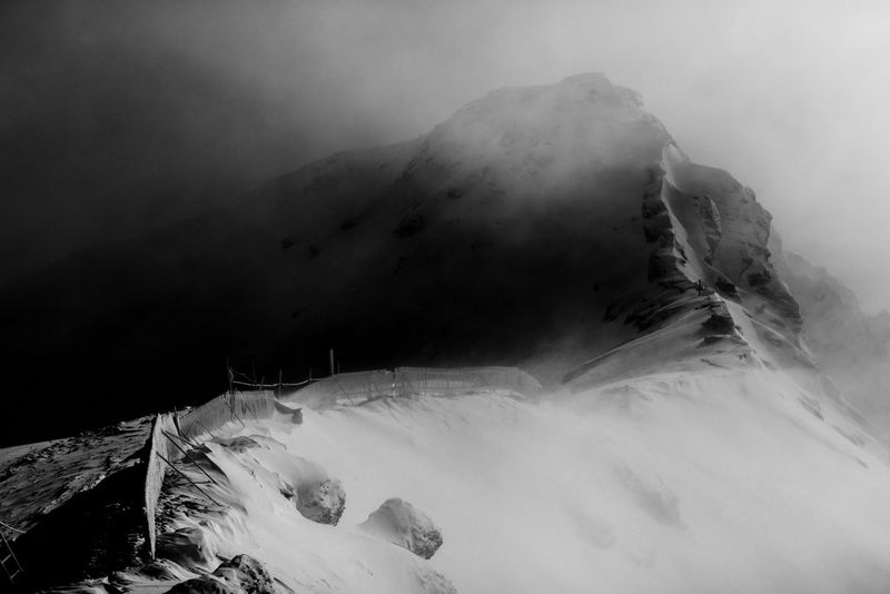 Scatto in bianco e nero della foschia mattutina sulla cima innevata dello Schilthorn, in Svizzera.