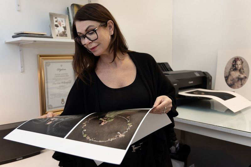 Photographer Martina Wärenfeldt looks at a large-format print of fine art portraits, printed on a Canon imagePROGRAF PRO-1000 printer visible in the background.
