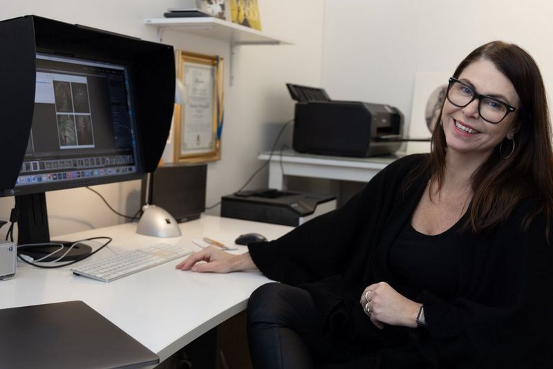 Photographer Martina Wärenfeldt sits in front of a self-calibrating computer screen, with a laptop and Canon imagePROGRAF PRO-1000 printer beside her. 