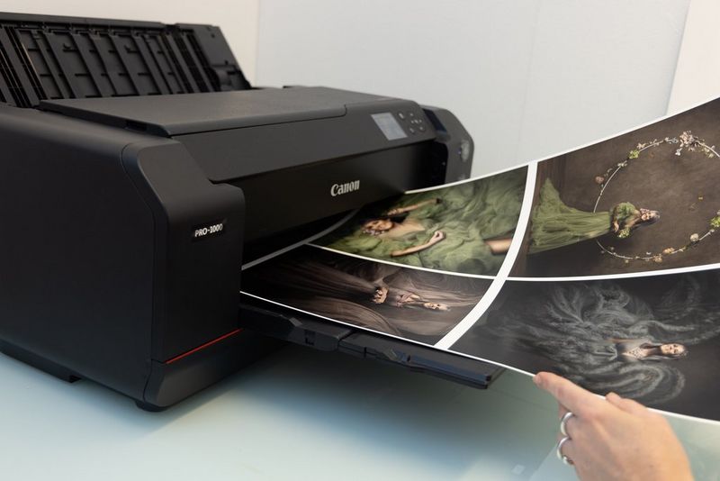 A sheet of fine art paper emerges from a Canon imagePROGRAF PRO-1000 printer, with four fine art portraits by photographer Martina Wärenfeldt printed on it.