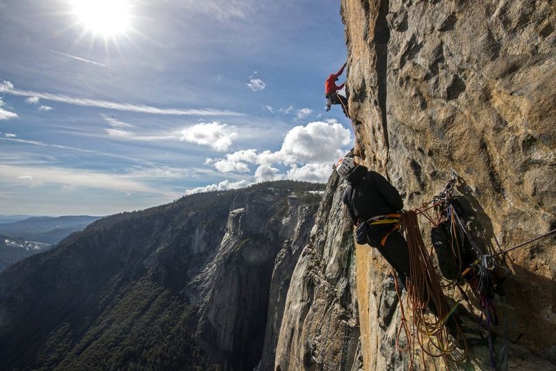 Ein Kletterer hängt von der Steilklippe des El Capitan im Yosemite-Nationalpark und hält ein Sicherheitsseil, während ein anderer ungesichert über ihm klettert.