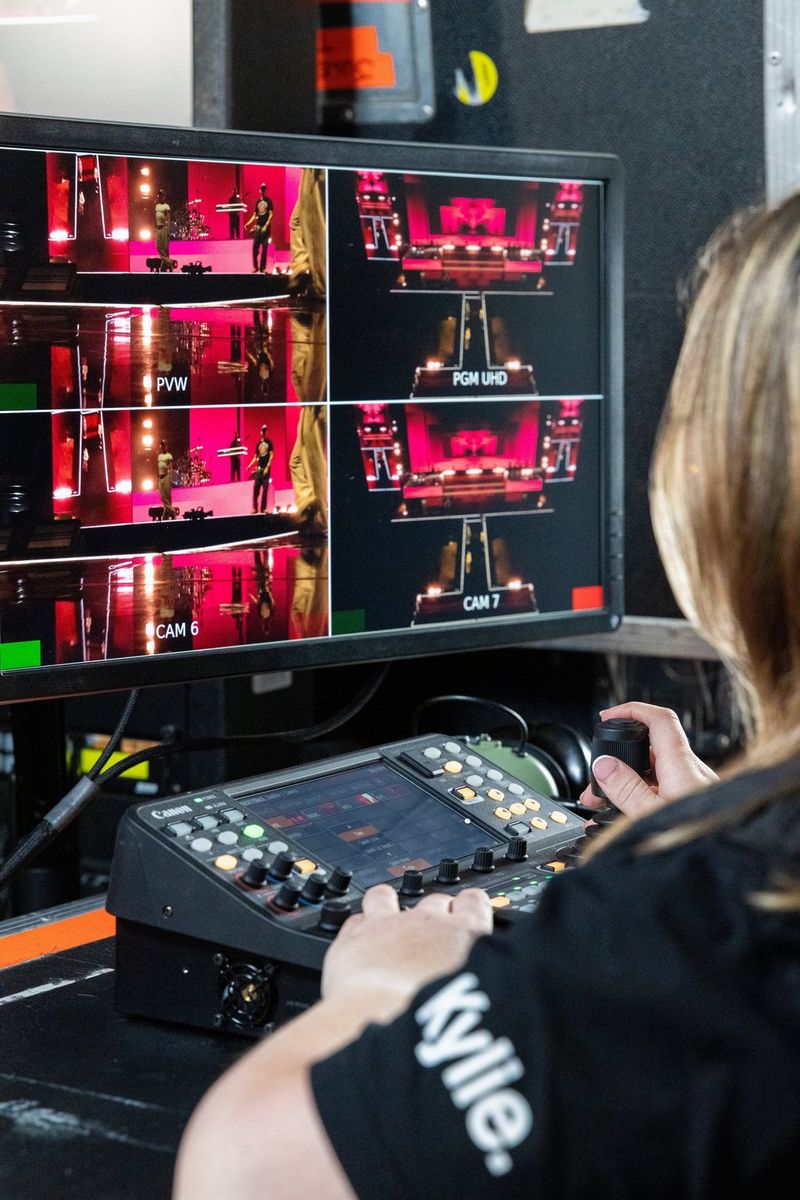 PTZ operator Harriet Woollam operates the joystick on the Canon RC-IP1000 PTZ controller while looking at multiple camera feeds on a screen.