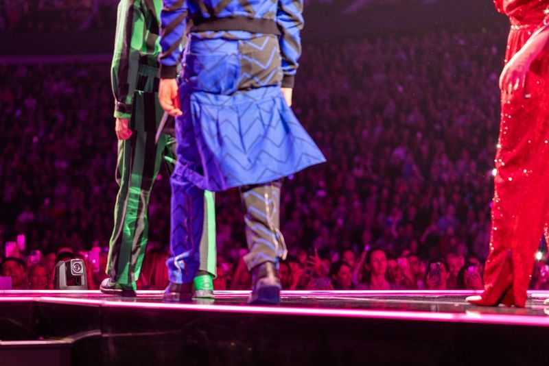 The Canon CR-N700 PTZ camera is barely visible at the front of the stage between the legs of performers during a live performance. 