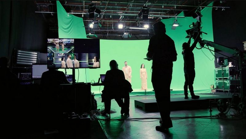 Aufnahmen der Future Games Show, zwei Moderatoren stehen vor einem Green Screen und das Produktionsteam zeichnet sich im Vordergrund ab.