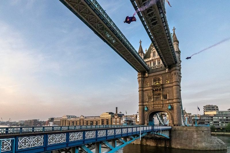 Two wingsuiters fly between the towers of London's Tower Bridge, under the high-level walkway. Captured on Canon.