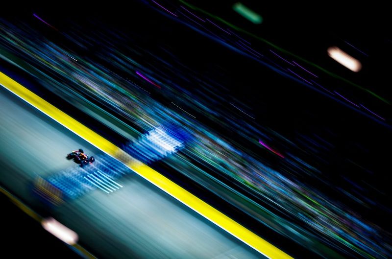 Auto su una pista da corsa, con ambiente circostante sfocato dal movimento.