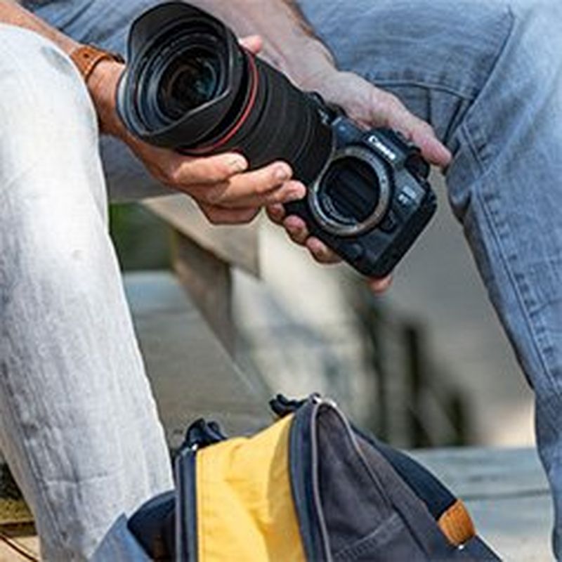 A filmmaker changing an RF lens on the Canon EOS R5.