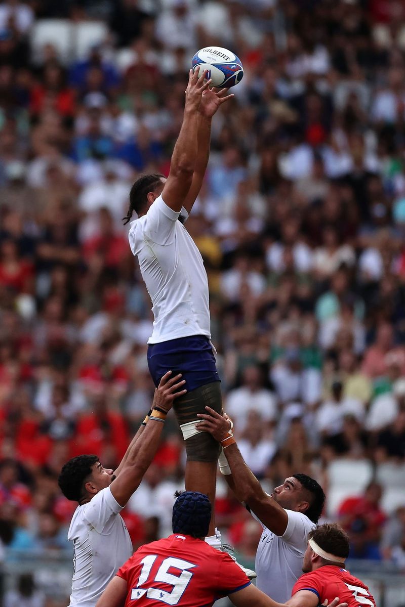 Due giocatori samoani sollevano un compagno di squadra perché prenda il pallone mentre due giocatori cileni li guardano, in una foto scattata alla Coppa del Mondo di rugby 2023 con una Canon EOS R3 da Manaui Precious Naumalila Ash-Faulalo.