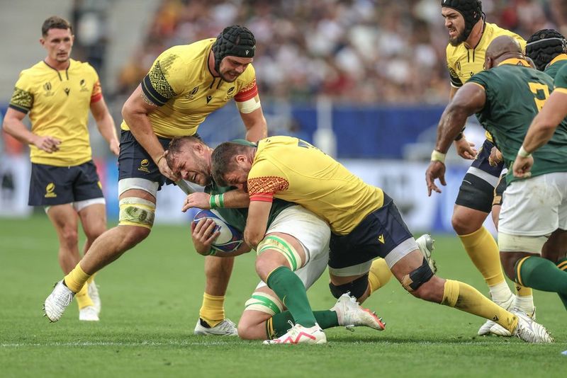 Un giocatore rumeno placca un giocatore sudafricano mentre i compagni di squadra corrono verso l'azione in uno scatto realizzato alla Coppa del Mondo di rugby 2023 con Canon EOS R3 da Siyamazi Khathola.