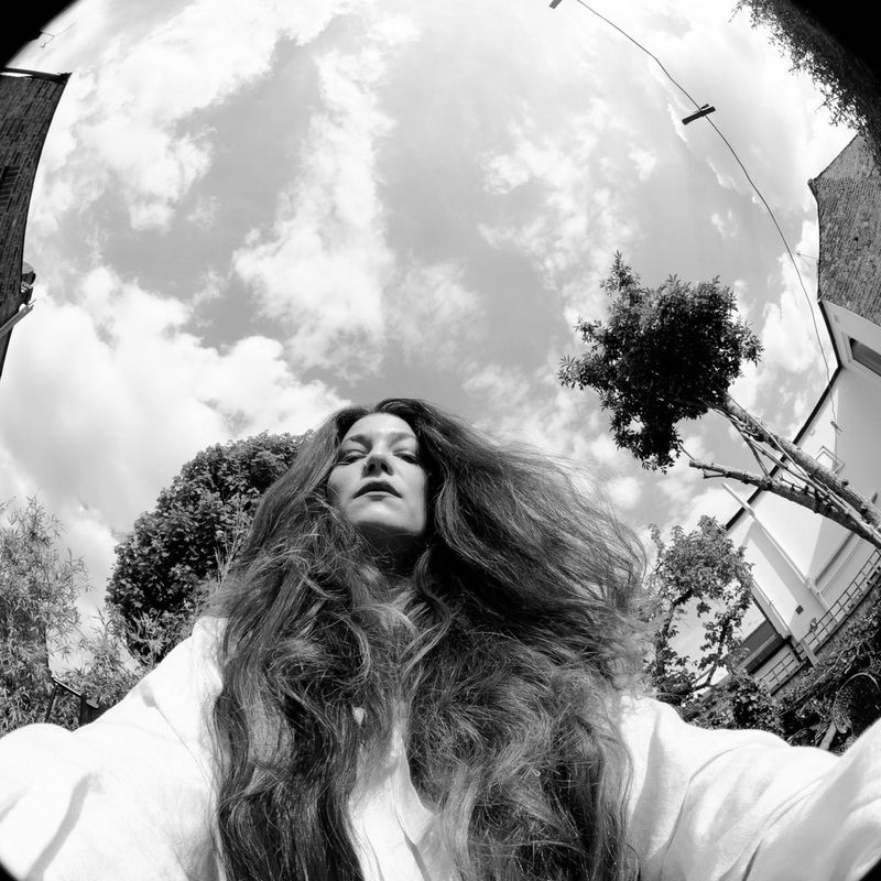 A black-and-white image shot with a fisheye lens of Canon Ambassador Wanda Martin looking down at the camera, her long hair falling around her shoulders.