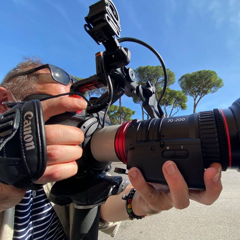 Мужчина держит камеру Canon EOS C300 Mark II с объективом Canon CN-E70-200mm T4.4 L IS.