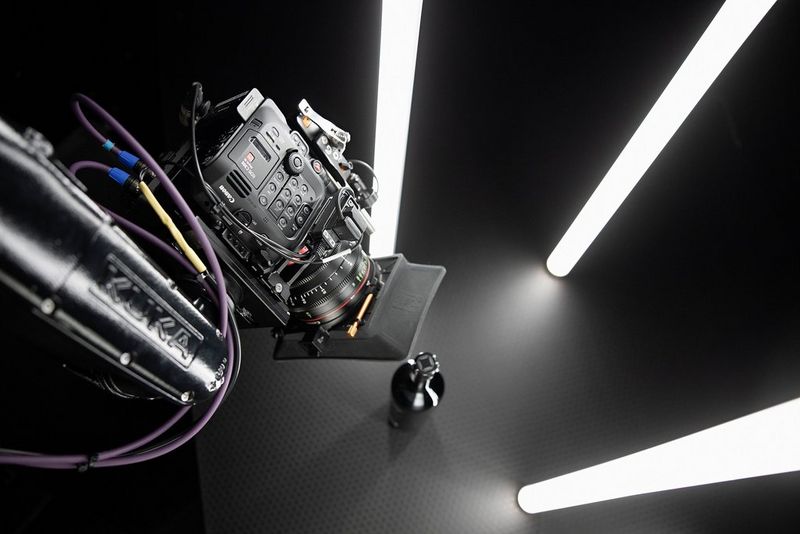 Una videocamera Canon EOS C300 Mark III è ritratta su uno sfondo scuro con tubi di luce bianca brillante intorno.