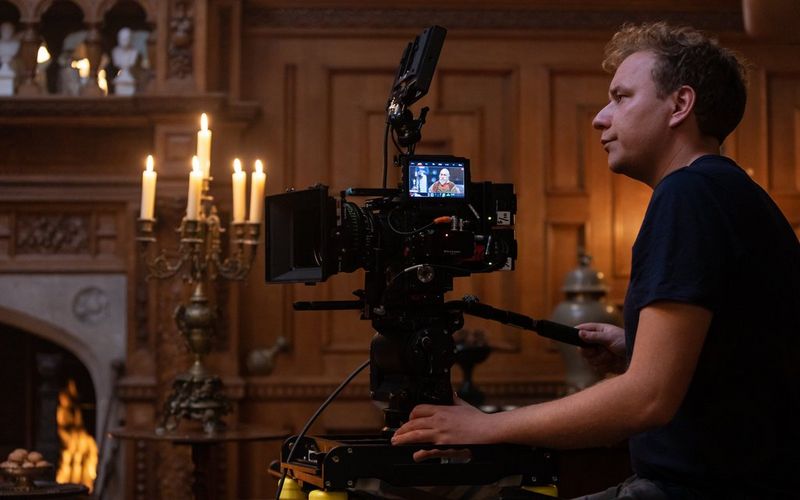 Clemens Majunke filming with a Sumire Prime lens in a room lit by candles and a fireplace.