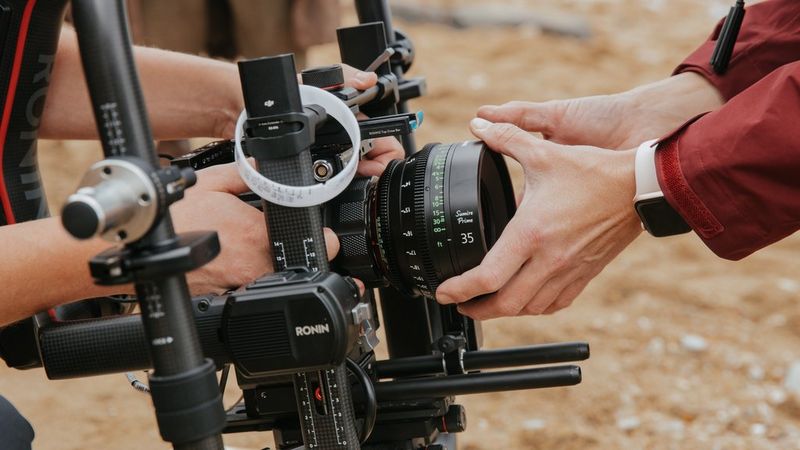 A Sumire Prime CN-E35mm T1.5 FP X lens being attached to a camera mounted on a gimbal.