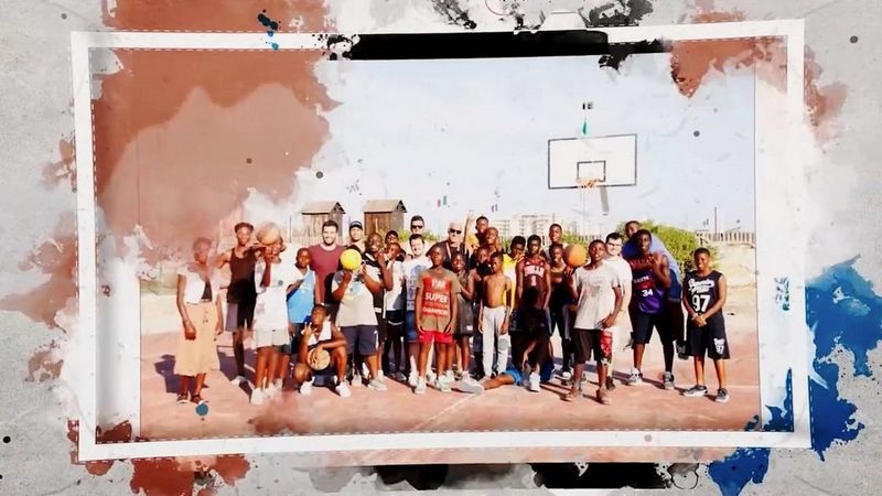 La troupe di Tam Tam Basket in piedi su un campo da basket con un gruppo di giovani giocatori.