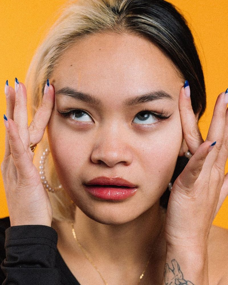 Een portretfoto van Trae Nguyen tegen een gele achtergrond.