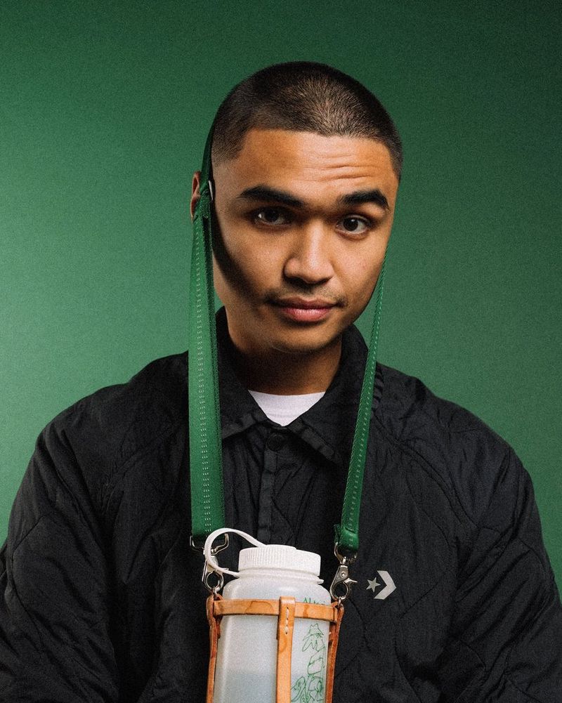 Een portretfoto van Due Pinlac tegen een groene achtergrond.