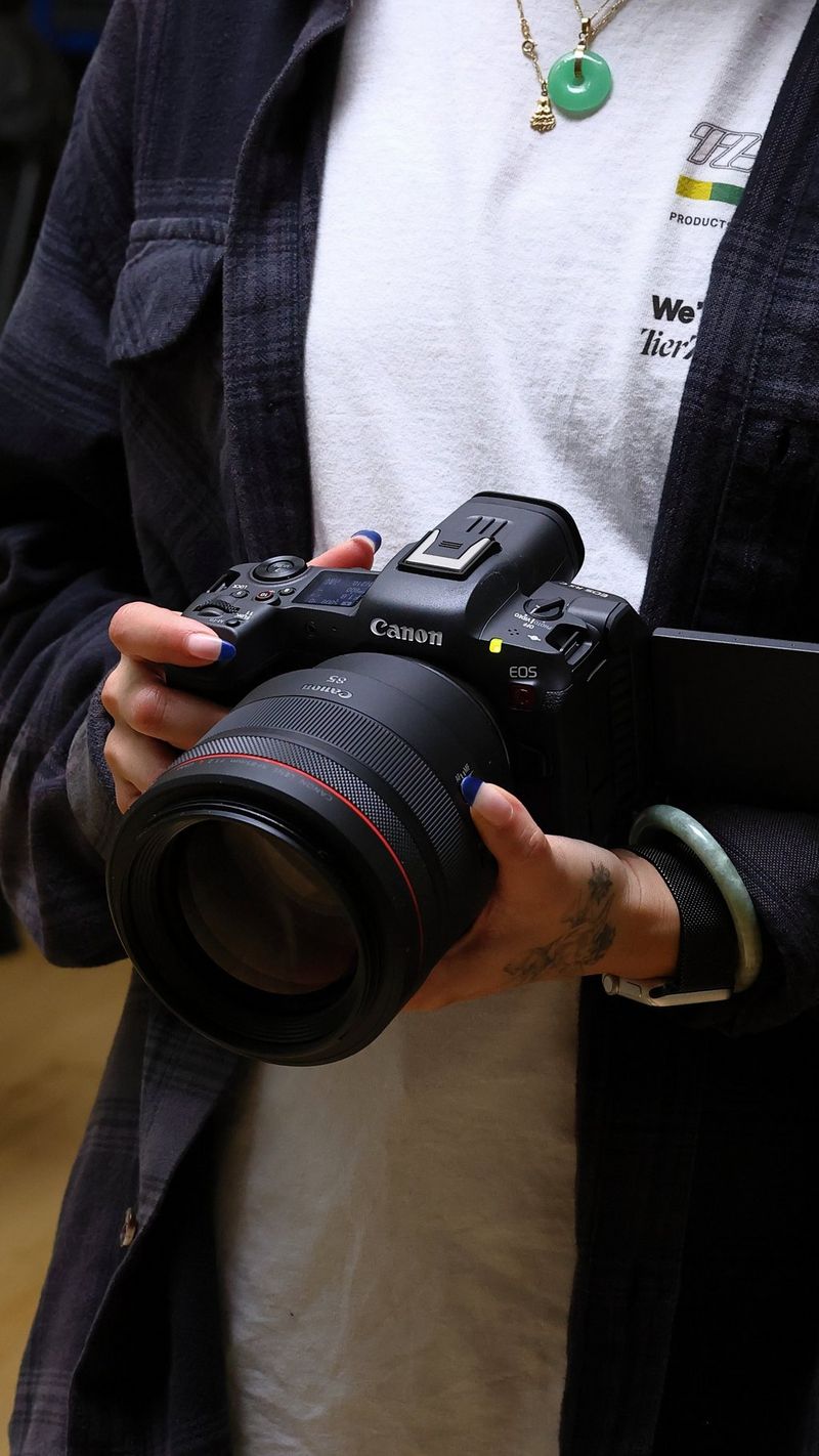 Een close-up van een persoon die op borsthoogte filmt met een Canon EOS R5 C-camera.