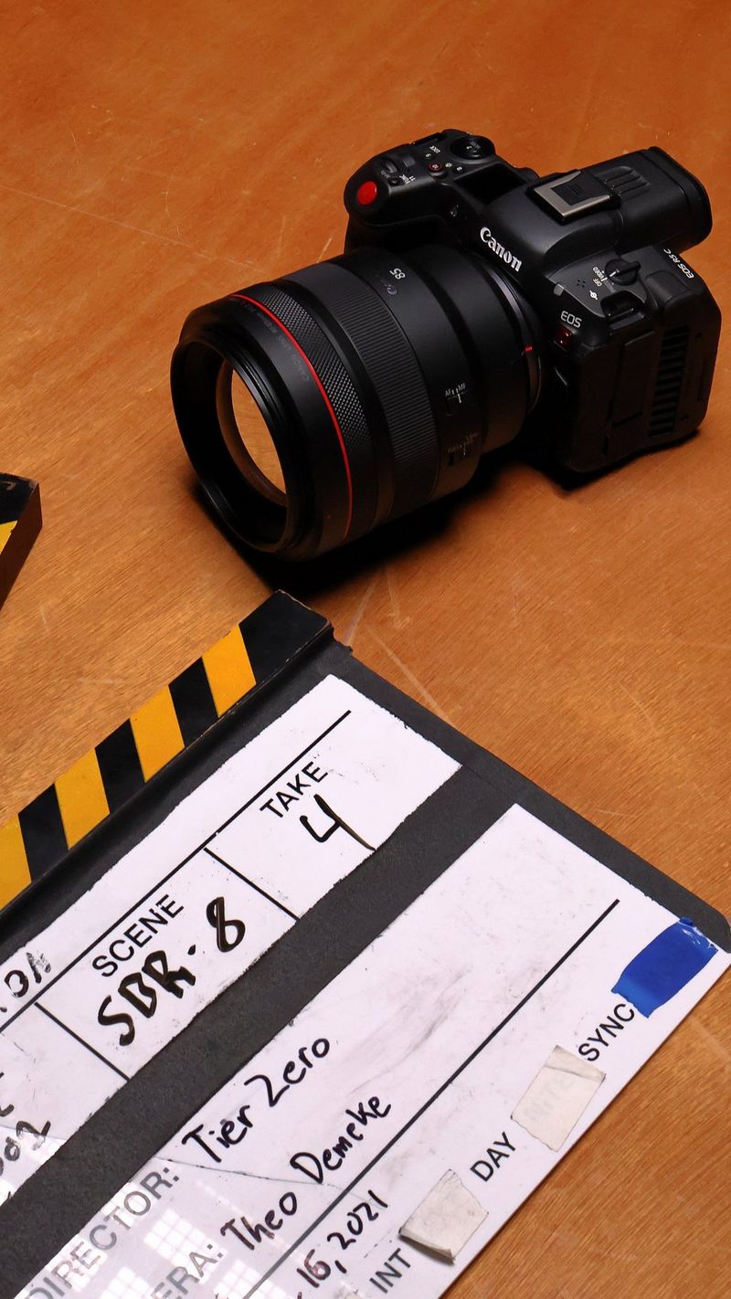 De Canon EOS R5 C ligt op een tafel naast een filmklapper.
