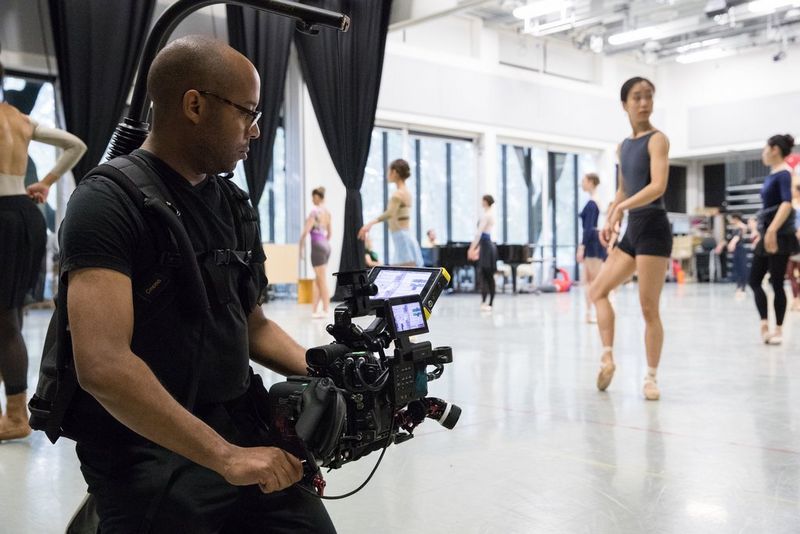 A man filming a dance class with a Cinema EOS camera on a gimbal.