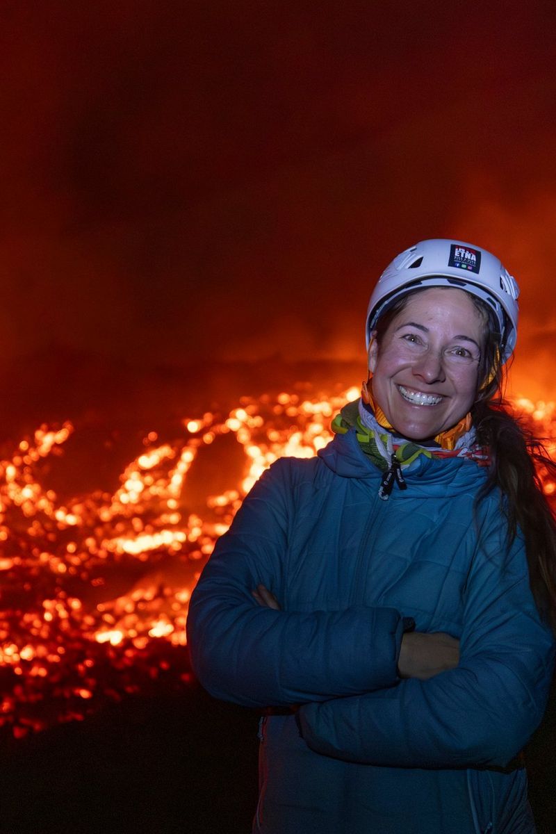 Adventure photographer and filmmaker Ulla Lohmann pictured against a glowing lava flow.