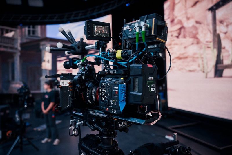 Een Canon EOS C400-camera op een statief, volledig uitgerust met een externe monitor en talloze andere accessoires.